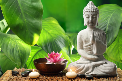 Buddha in meditation with lotus flower and burning candles